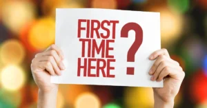 person holding up first time here sign