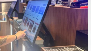 Bloom Akron customer choosing products on the menu screen at counter with budtender.