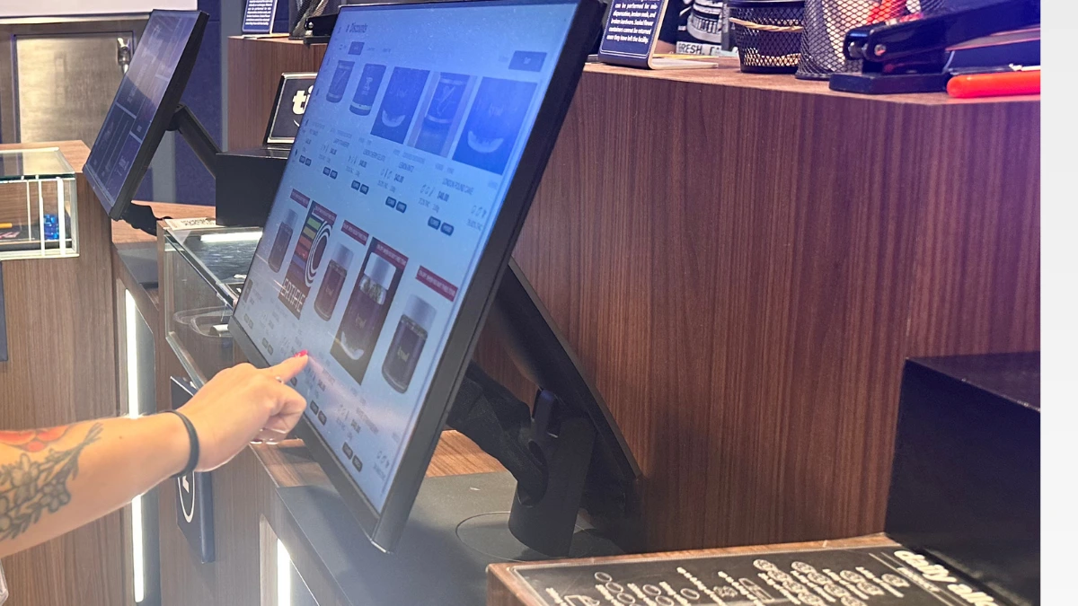 Bloom Akron customer choosing products on the menu screen at counter with budtender.